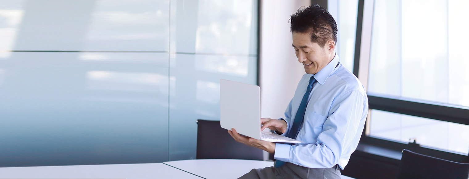 Businessman using laptop to contact HSBC commercial banking customer service