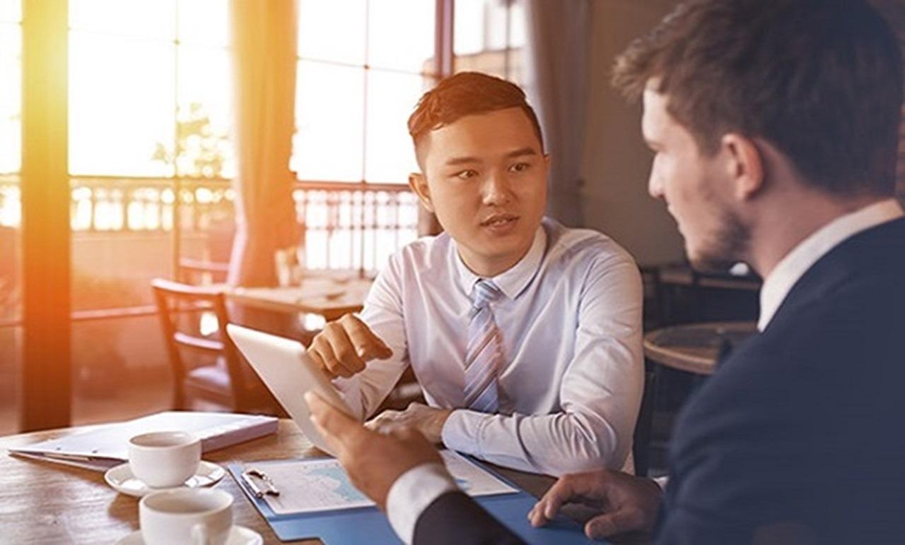 two businessmen accessing HSBCnet on their desktop computer two businessmen accessing HSBCnet on their desktop computer