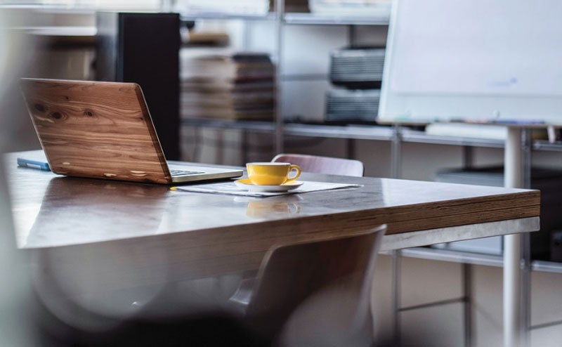 Desk with laptop and report papers for HSBC contactless solution under the yellow mug Desk with laptop and report papers for HSBC contactless solution under the yellow mug